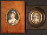 pair of miniature portraits of women in oval frames on a black background