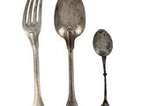 three spoons and a fork sitting next to each other