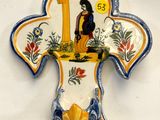 une croix en céramique ornée d'un oiseau, sur fond blanc