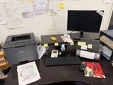 un bureau sur lequel se trouvent un ordinateur, une imprimante et d'autres fournitures de bureau