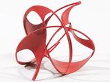 une sculpture rouge sur une surface blanche, avec un fond blanc