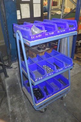 a blue cart with blue bins on it in a garage