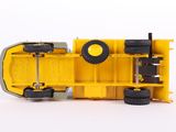 a yellow toy truck that is sitting on a white surface