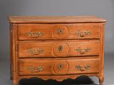une commode ancienne avec un plateau en bois et des poignées en laiton