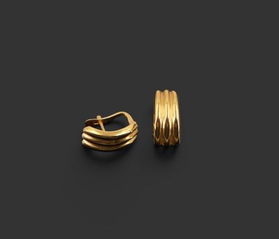 une paire de boucles d'oreilles en or sur fond noir