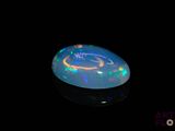 an image of a black opal in the dark