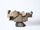 a sculpture made out of cardboard on a rock