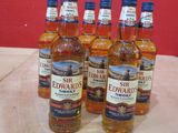 six bouteilles de whisky posées sur une table, avec un mur rouge en arrière-plan