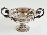 an antique silver plated bowl with handles and handles on a white surface