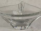 glass bowl on a table with a white cloth and a white wall in the background