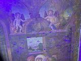 a painting on the wall of a room with a purple light
