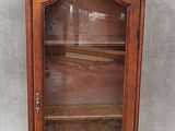 une vitrine ancienne en bois, dotée de portes vitrées et d'étagères