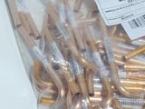 a bag of gold colored scissors on a white table