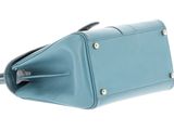 a close up of a blue purse on a white background