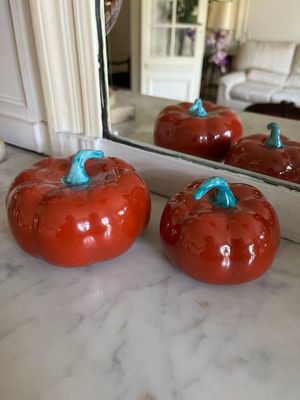 four tomatoes sitting on a counter in front of a mirror