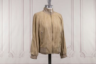 an image of a tan jacket on a mannequin stand in front of a white wall