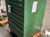 une caisse verte posée sur une palette dans un entrepôt