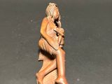 statue of a woman sitting on a stool holding a baby