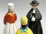 three figurines of people standing next to each other