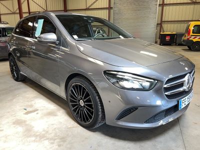une Mercedes CLA argentée garée dans un garage, avec d'autres voitures en arrière-plan