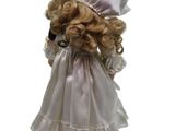 a doll with blonde hair wearing a white dress and hat