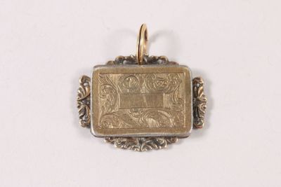 a small gold pendant with a picture of a man on it
