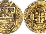 a close up of two gold coins on a white surface