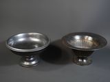 pair of silver plated bowls on pedestals against a gray background