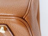 a close up of a brown leather bag with a zipper