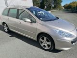 the silver car is parked in a parking lot near a building