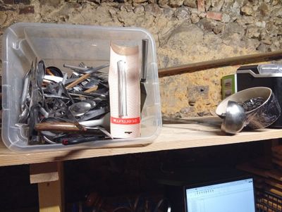 many spoons and spoon spoons sitting on a shelf next to a laptop