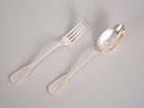 two silver spoons and a fork on a white surface