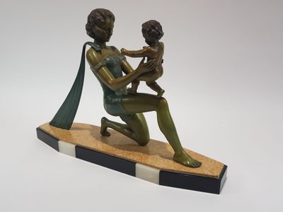 statue en bronze représentant une femme tenant un enfant sur une planche de surf