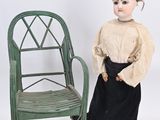 an image of a doll sitting next to a chair on a white background