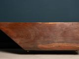 an old wooden bath tub sitting on top of a cement floor