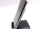 a cell phone that is on a stand on the table
