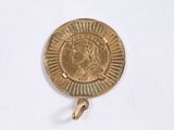 an image of a gold coin hanging from a hook on a white surface