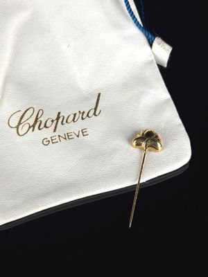 un petit sac blanc orné d'une broche dorée