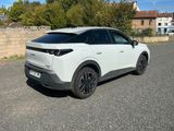 un SUV blanc garé sur un parking près d'un mur en pierre