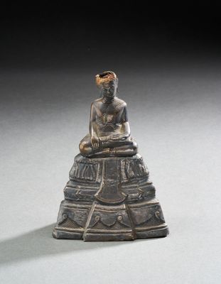une image représentant une statue d'une personne assise sur un rocher