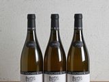 trois bouteilles de vin posées sur une table en bois