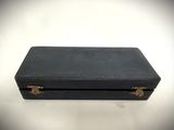 an old black suitcase sitting on top of a white table