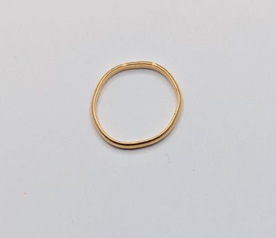 gros plan d'une bague en or sur une surface blanche