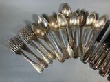 a lot of silver spoons and forks on the table