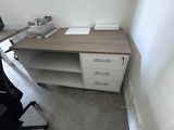 a desk with a chair and a computer on it