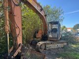 a small excavator that is sitting in the grass