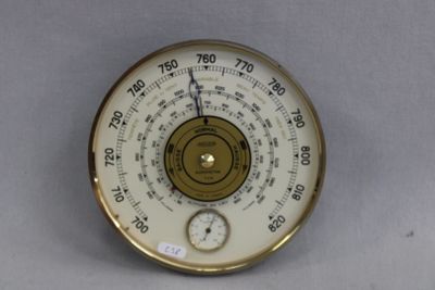une horloge accrochée au mur et équipée d'un thermomètre