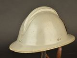an old white helmet with a leather strap on a black background