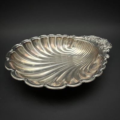 une assiette en argent ornée d'un grand motif en forme de coquillage