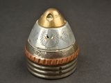 a small silver and gold object on a black surface